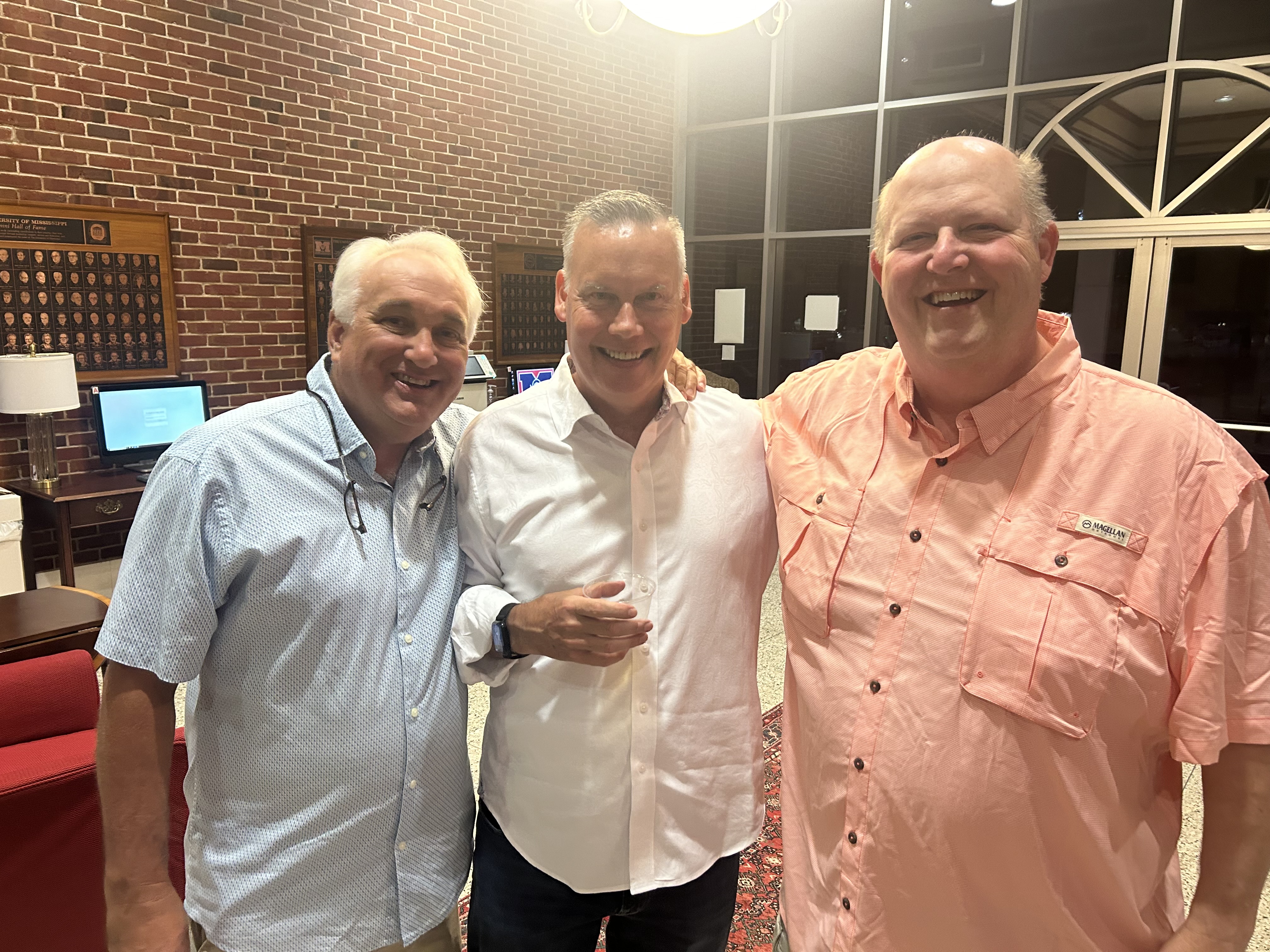 Three alumni reconnecting at the chapter house